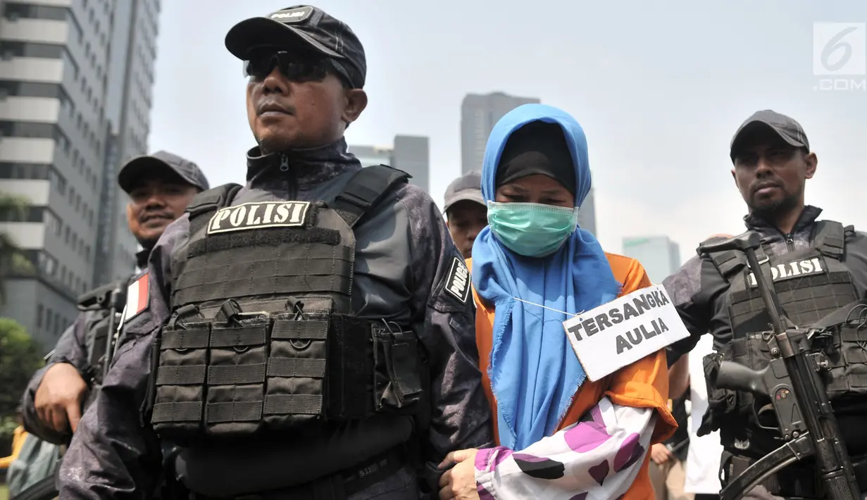 Tersangka Aulia Kesuma (tengah) digiring polisi saat dihadirkan dalam kasus istri bunuh dan bakar suami serta anak tiri di Polda Metro Jaya, Jakarta, Senin (9/9/2019). Aulia dan model yang memerankan tersangka Kelvin memeragakan tiga adegan pembakaran korban dalam mobil. (merdeka.com/Iqbal Nugroho)