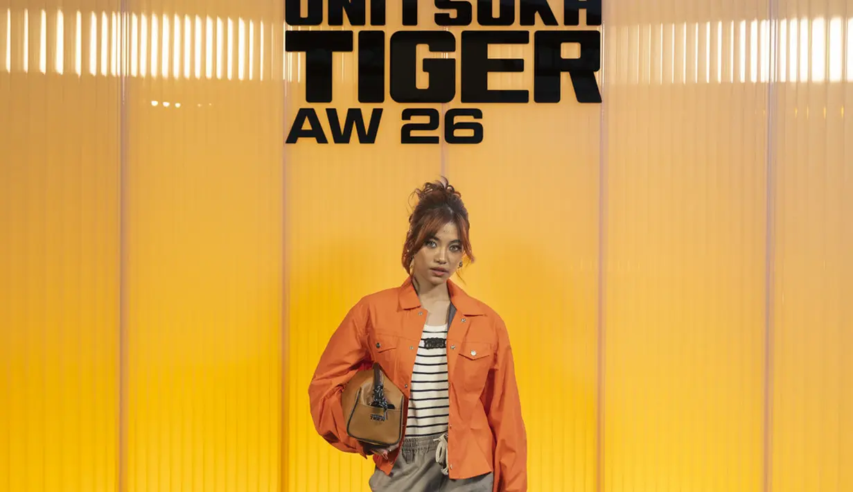Sementara itu, Haven Teo membawa energi warna lewat jaket oranye terang yang dipadukan dengan atasan bergaris dan celana pendek bernuansa netral. Tas tangan cokelat serta sepatu loafers memberi sentuhan playful namun tetap polished, menciptakan gaya yang segar dan modern. [Dok/OnitsukaTiger].