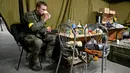 Pasukan Pertahanan Teritorial Ukraina, cadangan militer Angkatan Bersenjata Ukraina, makan siang di garasi bawah tanah yang telah diubah menjadi pangkalan pelatihan dan logistik di Kiev, pada Jumat (11/3/2022). (Sergei SUPINSKY / AFP)