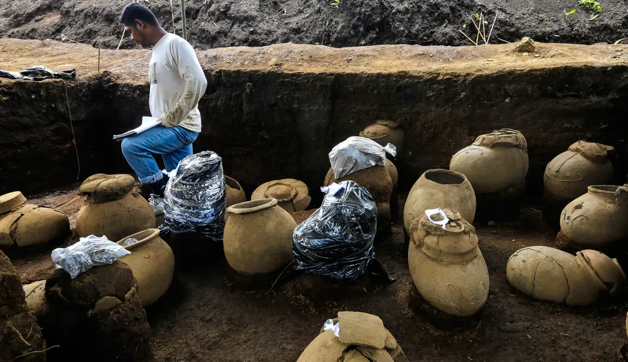 Pekerja Nicaraguan Institute of Culture (INC) mendata sejumlah tembikar di situs pemakaman zaman pra-Kolombia berusia lebih dari 1.200 tahun yang ditemukan di lokasi pembangunan Stadion Bisbol Nasional yang baru di Managua, Selasa (20/6). (INTI OCON/AFP)
