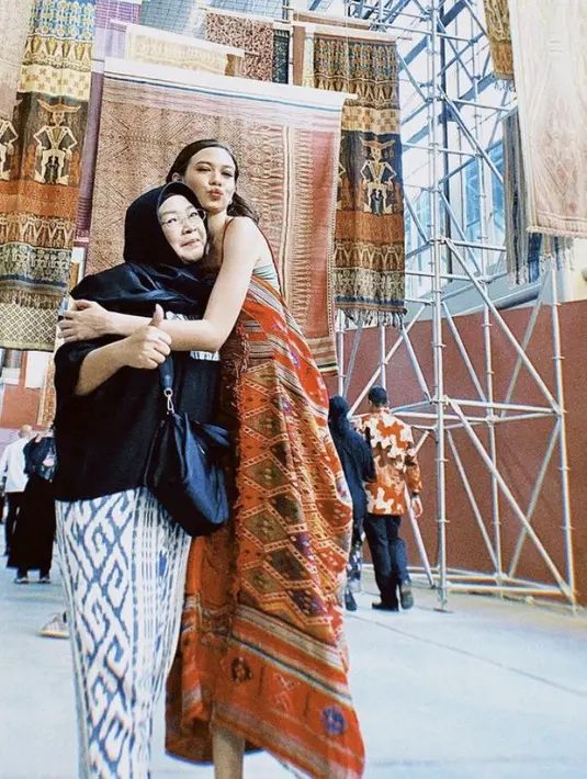 Yuki dan sang ibunda tampil bernuasa Indonesia lewat busana yang dikenakan. Yuki tampil mengenakan kain tenun yang dijadikan dress, sedangkan ibunda dengan kain lilit dipadukan atasan hitam. (@yukikt)