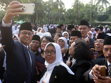 Gubernur DKI Jakarta Anies Baswedan berswafoto usai melantik dan mengambil sumpah jabatan pejabat fungsional di halaman Balai Kota DKI Jakarta, Senin (4/6). Sebanyak 916 pejabat fungsional dilantik hari ini. (Liputan6.com/Arya Manggala)