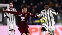 Pemain Juventus, Paul Pogba (kanan) berebut bola dengan pemain Torino, Jacopo Segre pada laga lanjutan Liga Italia 2022/2023 yang berlangsung di Allianz Stadium, 28 Februari 2023. Ini merupakan laga debut kedua bagi Pogba bersama Juventus. (AFP/Marco Bertorello)