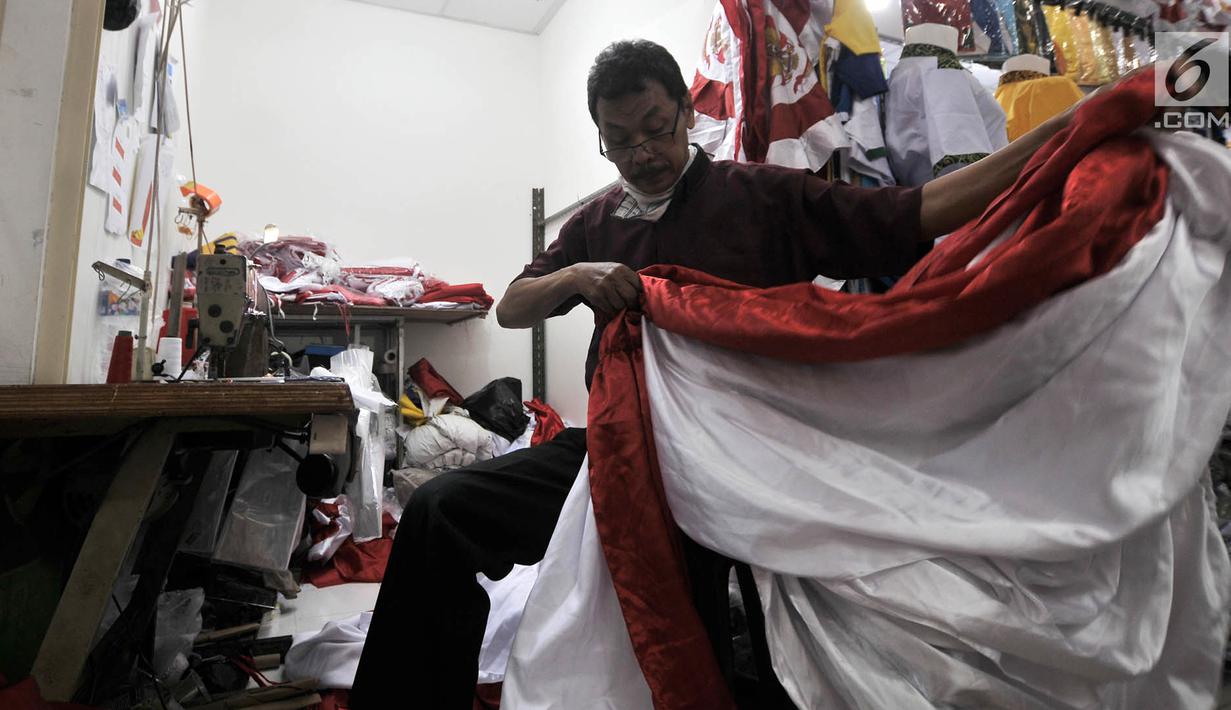 Penjahit merapikan bendera Merah Putih di Pasar Senen, Jakarta, Kamis (2/8). Salah seorang penjahit mengaku pesanan bendera Merah Putih meningkat hingga 50 persen dibandingkan bulan-bulan sebelumnya. (Merdeka.com/Iqbal Nugroho)