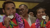 Lifter Indonesia, Eko Yuli dan Sri Wahyuni menunjukan medali perak yang didapatnya saat Olimpiade 2016 Rio de Janeiro ketika tiba di Bandara Soekarno-Hatta, Tanggerang, Banten, Minggu (14/8/2016). (Bola.com/Vitalis Yogi Trisna)