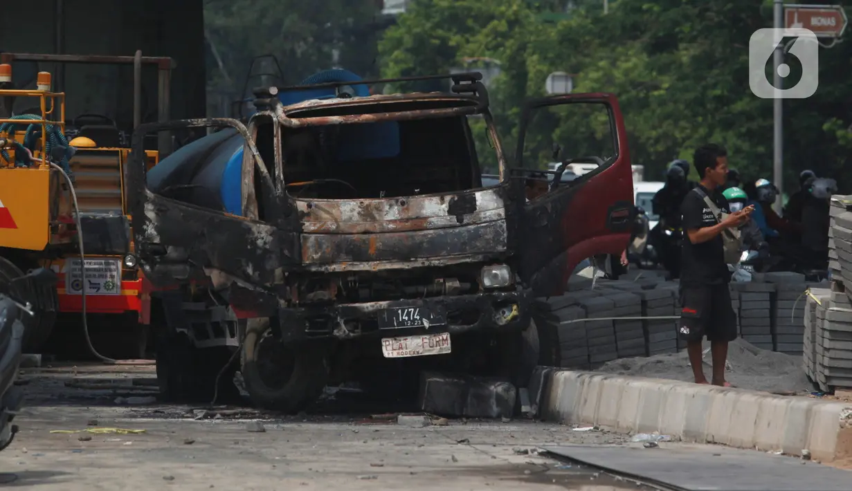 Kondisi mobil proyek yang hangus terbakar saat unjuk rasa menolak pengesahan Undang-Undang Cipta Kerja di kawasan Senen, Jakarta, Jumat (9/10/2020). Unjuk rasa tersebut berakhir ricuh dan mengakibatkan sejumlah fasilitas umum rusak. (Liputan6.com/Angga Yuniar)