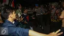 Massa aksi berhadapan dengan petugas polisi saat menggelar aksi unjuk rasa di depan Istana Negara, Kamis (12/1). Massa mahasiswa berkumpul di depan Istana di kawasan Jalan Merdeka Barat dengan membakar ban. (Liputan6.com/Faizal Fanani)