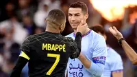 Pemain PSG, Kylian Mbappe (kiri) berbincang dengan Cristiano Ronaldo saat laga Riyadh Season Cup antara Riyadh All-Star melawan PSG yang berlangsung di King Fahd Stadium, Riyadh, Jumat (20/1/2023) dini hari WIB. (AFP/Franck Fife)