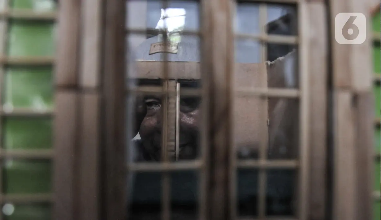 Jimmy Alexander (52) saat menyelesaikan pembuatan kerajinan miniatur rumah ibadah di kediamannya di kawasan Kalipasir Dalam, Cikini, Jakarta Pusat, Senin (5/9/2022). Untuk memberi kesan nyata, Jimmy juga memberikan lampu pada miniatur rumah yang dibuatnya. (merdeka.com/Iqbal S Nugroho)