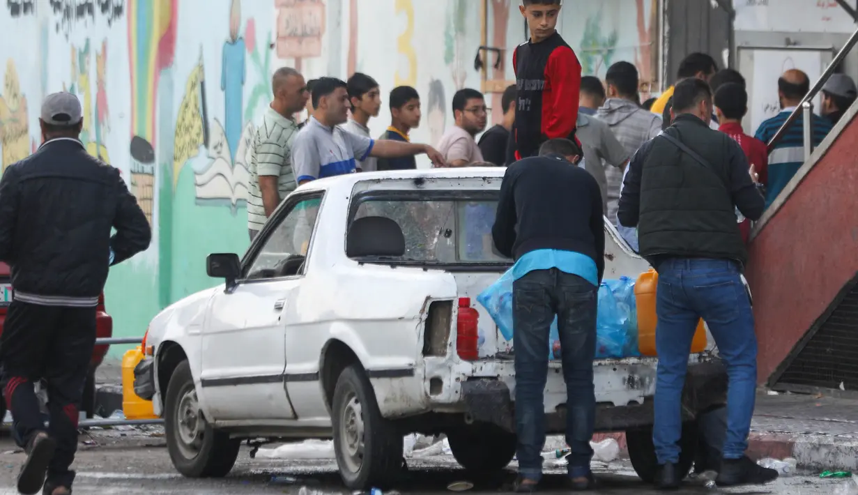 Warga Palestina mengantre untuk mengisi tabung air di Kota Gaza, pada 16 Oktober 2023. (Dawood NEMER/AFP)