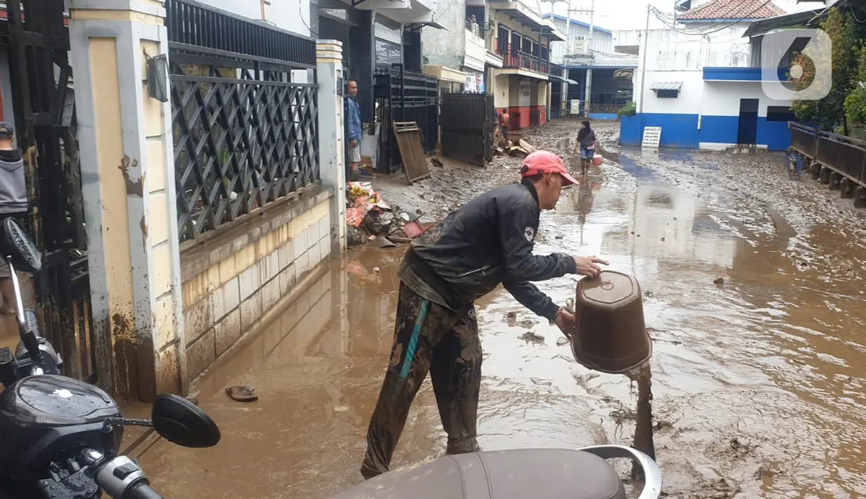 <p>Warga membersihkan lumpur sisa dari banjir bandang Garut di kawasan Cimacan, Desa Jayaraga, Kecamatan Tarogong Kidul, Sabtu (16/7/2022). Pemda Garut, Jawa Barat menyatakan status darurat banjir setelah 8 kecamatan di wilayah tersebut terendam banjir usai Sungai Cimanuk dan beberapa anak sungainya meluap. (Liputan6.com/Jayadi Supriadin)</p>