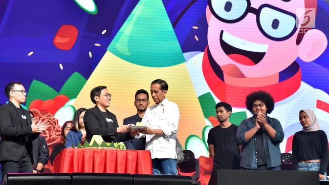 Presiden Joko Widodo menerima tumpeng dari Founder dan CEO Bukalapak Achmad Zaky selama acara hari ulang tahun (HUT) ke-9 BukaLapak di Jakarta Convention Center (JCC), Kamis (10/1). (Liputan6.com/HO/Biropers)