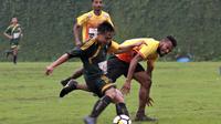 Bek Persipura, Israel Wamiau, berjibaku dalam uji coba melawan Putra Jaya dalam kondisi hujan. (Bola.com/Iwan Setiawan)
