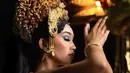 Perempuan berusia 19 tahun ini mengenakan pakaian khas Bali lengkap dengan riasan mahkota emas yang biasa dikenakan perempuan Bali. Dengan riasan wajah bold, ia mengenakan eyeshadow biru dengan lipstik brown. (@thesophiarogan)
