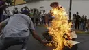 Patung bergambar Presiden Venezuela Nicolas Maduro dibakar oleh warga di Caracas , Venezuela, (27/3). Proses ini juga masuk dalam tradisi " Pembakaran Yudas " tetapi bedanya patung tersebut ditempel gambar Nicolas Maduro. (REUTERS / Marco Bello)