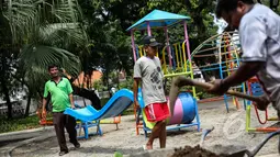 Sejumlah pekerja mengangkat papan perosotan saat proyek pembangunan Ruang Publik Terpadu Ramah Anak (RPTRA) di Jalan Tidore RW 05, Kelurahan Cideng, Gambir, Jakarta, Senin (4/5/2015). (Liputan6.com/Faizal Fanani)
