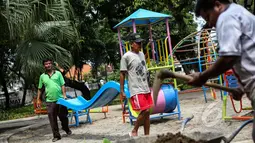 Sejumlah pekerja mengangkat papan perosotan saat proyek pembangunan Ruang Publik Terpadu Ramah Anak (RPTRA) di Jalan Tidore RW 05, Kelurahan Cideng, Gambir, Jakarta, Senin (4/5/2015). (Liputan6.com/Faizal Fanani)