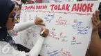 Massa dari Indonesia Bergerak menggelar aksi menolak Gubernur DKI, Basuki Tjahaja Purnama (Ahok) di Patung Arjuna Wiwaha, Jakarta, Kamis (22/9). Mereka membubuhkan cap jempol menggunakan darah sebagai simbol penolakannya. (Liputan6.com/Immanuel Antonius)