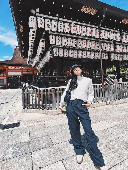 Gaya chic casual lainnya dari Maudy Ayunda. Ia memadukan turtle-neck sweater lengan panjang berwarna putih dengan celana panjang biru navy. Ia juga menambahkan bucket hat biru untuk kesan yang lebih kasual. Foto: Instagram.