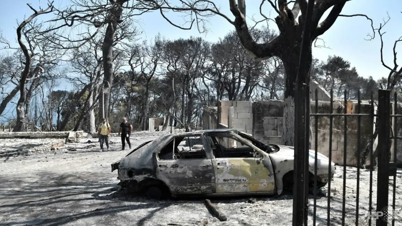 Sebuah mobil hancur dilalap api di timur Patras di Peloponnese saat Yunani memerangi kebakaran selama gelombang panas yang mengancam. (Foto: AFP/Louisa Gouliamaki)