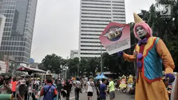 Badut menyosialisasikan sistem tilang Electronic Traffic Law Enforcement (ETLE) kepada pengunjung car free day (CFD) di Bundaran HI, Jakarta, Minggu (25/11). Sistem tilang ETLE telah dilakukan uji coba pada Oktober lalu. (Merdeka.com/Iqbal Nugroho)