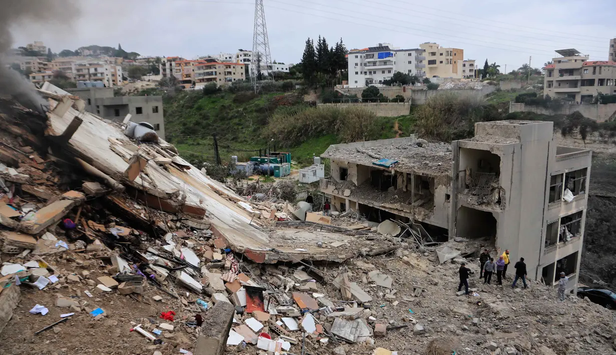 Serangan yang menghantam desa-desa seperti Qennarit memicu peringatan evakuasi massal bagi warga setempat. Tampak dalam foto, warga memeriksa bangunan-bangunan yang hancur akibat serangan Israel di desa Qennarit, Lebanon selatan, Kamis 22 Januari 2026. (AP Photo/Mohammed Zaatari)
