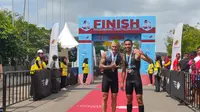 Jauhari Johan berfoto bersama Blake Keppler, peserta asal Australia di garis finish Palembang Triathlon 2020 (Liputan6.com / Nefri Inge)