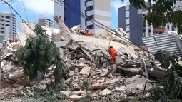Petugas pemadam kebakaran mencari korban setelah sebuah bangunan runtuh di Fortaleza, negara bagian Ceara, Brasil, Selasa (15/10/2019). Hingga saat ini, penyebab runtuhnya rumah susun tujuh lantai tersebut masih belum diketahui. (LC Moreira/Futura Press via AP)