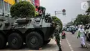 Seorang siswa berjalan dekat  Prajurit TNI dan  satu unit kendaraan Anoa di kawasan LTC Glodok, Jakarta, Jumat (18/10/2019). Penjagaan tersebut guna memberikan rasa aman bagi masyarakat menjelang pelantikan presiden dan wakil presiden terpilih, 20 Oktober 2019. (Liputan6.com/Faizal Fanani)