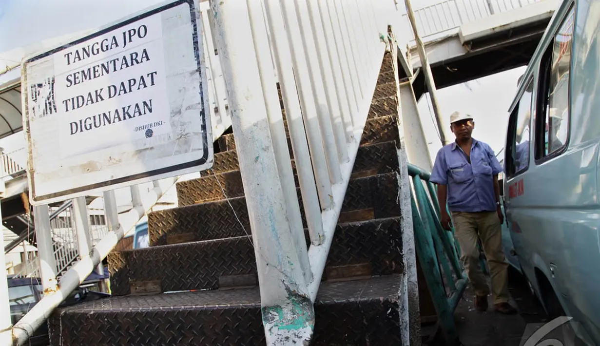 Seorang warga melintas di samping JPO di Terminal Kampung Melayu, Jakarta, (3/10/14). (Liputan6.com/Johan Tallo)