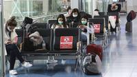 Orang-orang yang mengenakan masker beristirahat di lobi Bandara Internasional Haneda di Tokyo, Senin (28/12/2020). Jepang untuk sementara waktu melarang semua pendatang asing yang bukan penduduk masuk sebagai bentuk antisipasi varian baru COVID-19 hingga akhir Januari 2021. (AP Photo/Koji Sasahara)