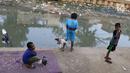 Anak-anak bermain di bantaran anak Sungai Ciliwung, Jakarta, Rabu (6/6). Meskipun tidak layak sebagai tempat bermain, namun lokasi itu menjadi tempat bagi anak-anak di kawasan tersebut untuk menunggu waktu berbuka. (Liputan6.com/Immanuel Antonius)