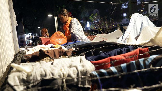 Pencari suaka menjemur pakaian di luar tenda yang dibangun di atas trotoar depan kantor UNHCR, Jalan Kebon Sirih, Jakarta, Jumat (5/7/2019). Para pencari suaka dari sejumlah negara berkonflik berharap UNHCR bisa segera memberikan jaminan perlindungan bagi mereka. (Liputan6.com/Helmi Fithriansyah)