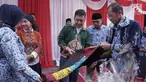 Kepala Departemen Komunikasi Perusahaan Semen Indonesia Sigit Wahono (tengah) bersama Bupati Magetan Suprawoto (kanan) mengamati batik ciprat karya siswa SMA/SMK/MA yang dipamerkan dalam acara #MembangunKemandirian di SMAN 1 Magetan Jawa Timur (2/5/2019). (Liputan6.com/HO/Eko)