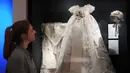 Busana ini merupakan pilihan pribadi mendiang Ratu Elizabeth II, mulai dari masa kecil hingga saat pemerintahannya. Tampak dalam foto, Cecilia Oliver, Konservator Tekstil di Royal Collection Trust, melihat ke arah Jubah Pembaptisan Kerajaan dari tahun 1841 yang dikenakan oleh Putri Elizabeth yang dipamerkan di pameran 'Queen Elizabeth II: Her Life in Style', di The King's Gallery, Istana Buckingham, London, Inggris, Kamis 9 April 2026. (AP Photo/Kirsty Wigglesworth)