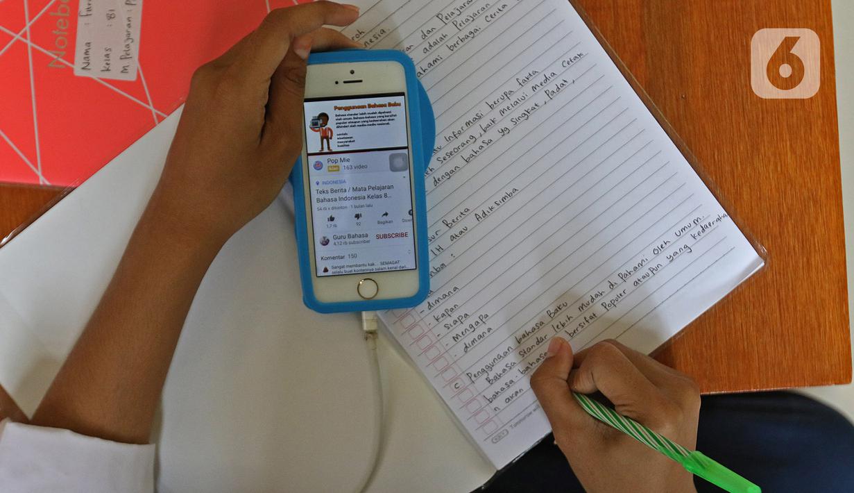 Siswa belajar di Aula Kelurahan Jatirahayu, Bekasi, Jawa Barat, Rabu (29/7/2020). Pemerintah Kota Bekasi melalui Kelurahan Jatirahayu menyediakan fasilitas wifi gratis bagi siswa yang terkendala kuota internet dalam kegiatan belajar secara daring. (Liputan6.com/Herman Zakharia)