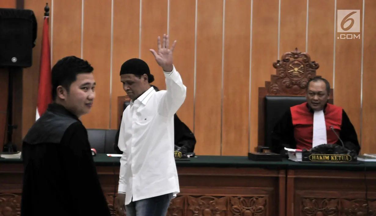 Terdakwa Hercules Rosario Marshal melambaikan tangan usai menjalani sidang perdana di PN Jakarta Barat, Rabu (16/1). Hercules menjalani sidang menggunakan kemeja putih dan peci hitam. (Merdeka.com/Iqbal Nugroho)