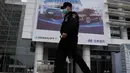 Seorang petugas keamanan berjalan melewati iklan untuk pameran Auto China 2020 yang akan digelar di Beijing, Kamis (24/9/2020). Menandai bangkitnya kembali industri otomotif negara dengan penduduk terbanyak di dunia ini, China mengumumkan siap menggelar Auto China 2020. (AP Photo/Ng Han Guan)