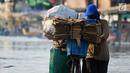 Seorang warga mendorong sepedanya melintasi banjir rob di jalan Yos Sudarso Semarang di kawasan Pelabuhan Tanjung Emas (24/4). Banjir akibat pasang air laut masih terjadi di sejumlah titik kota Semarang. (Liputan6.com/Gholib)