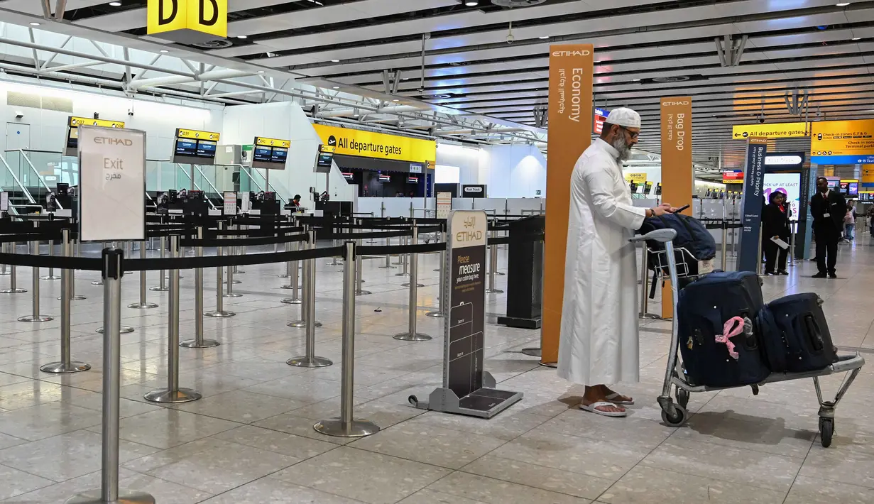 Diketahui, setidaknya ada delapan negara di kawasan Timur Tengah menyatakan menutup wilayah udaranya. Tampak dalam foto, seorang pria berdiri di depan konter check-in yang tutup milik maskapai penerbangan Etihad di Bandara Heathrow, London pada Minggu 1 Maret 2026. (JUSTIN TALLIS/AFP)