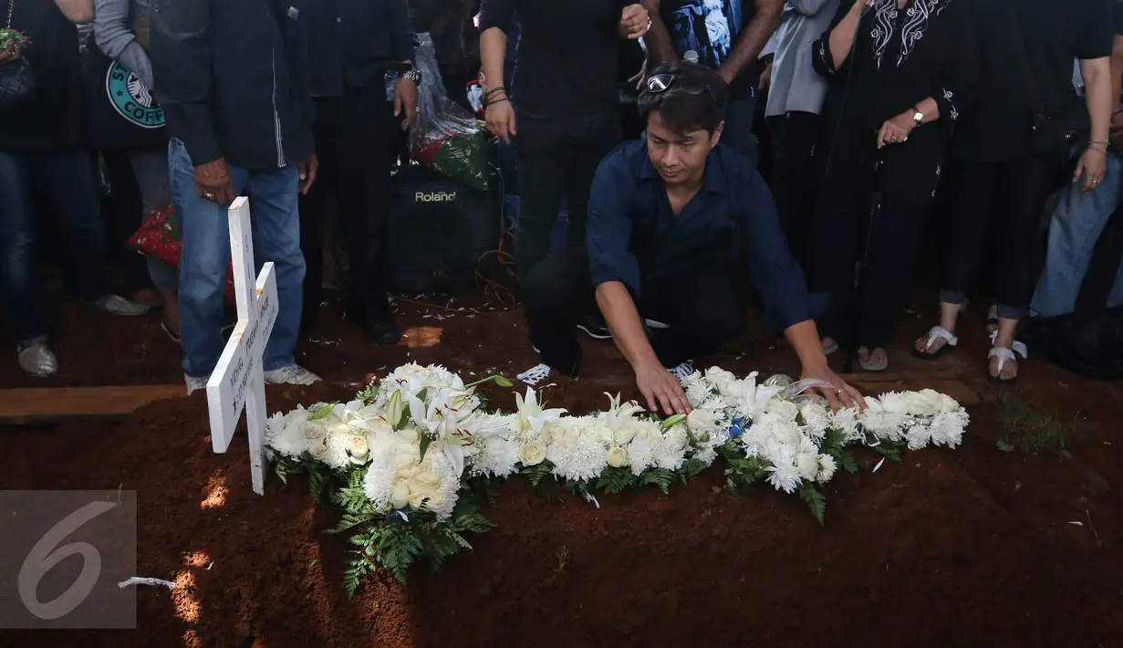 Penyanyi Delon meletakkan karangan bunga di atas makam Mike Mohede di TPU Tanah Kusir, Jakarta, Selasa (2/8). Sejumlah musisi dan selebriti ikut hadir untuk mengantar Mike Mohede ke peristirahatan terakhirnya. (Liputan6.com/Herman Zakharia)
