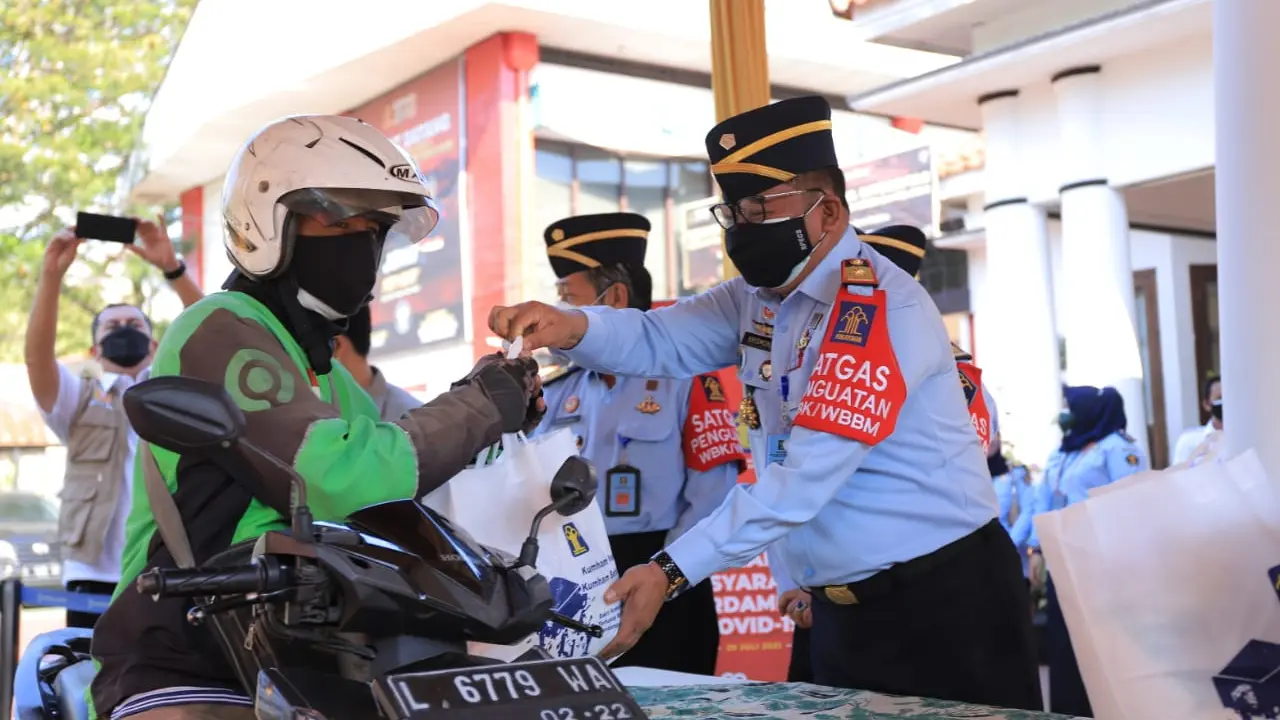 ASN Kemenkumham Jatim membagikan sembako untuk ojek online. (Dian Kurniawan/Liputan6.com)