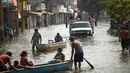 Warga melewati jalan banjir di Villahermosa, Meksiko, Rabu (11/11/2020). Banjir telah mempengaruhi ribuan orang di negara bagian pantai Teluk Tabasco. (AP Photo/Felix Marquez)