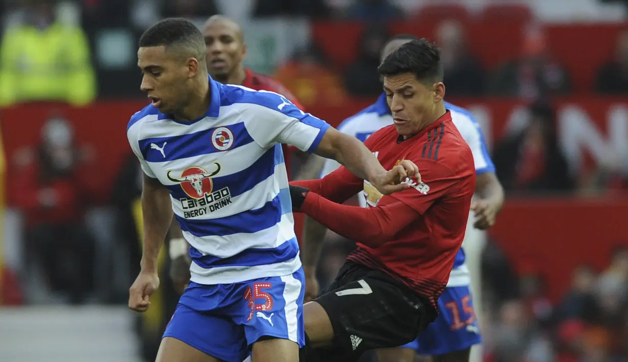 Striker Manchester United, Alexis Sanchez, berebut  bola dengan pemain Reading, Callum Harriott, pada laga Piala FA di Stadion Old Trafford, Sabtu (5/1). Manchester United menang 2-0 atas Reading. (AP/Rui Vieira)