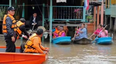 Perdana Menteri Thailand Prayuth Chan-ocha bersama tim SAR saat meninjau warga yang terjebak banjir di Distrik Sena, Ayutthaya, Thailand (5/10). Thailand mengatakan sekitar 96.000 hektare terendam dan banyak akses terputus.( Reuters/Chaiwat Subprasom)