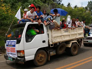 Sejumlah mobil membawa warga Marawi yang menyelamatkan diri dari pertempuran antara pasukan pemerintah dengan kelompok Maute, Filipina, Senin (29/5). Bendera putih dipasang agar mereka tidak diserang oleh pasukan pemerintah. (AP Photo / Bullit Marquez)