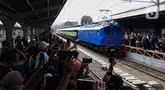 Warga menyaksikan rangkaian lokomotif listrik ESS 3200 tahun pembuatan 1927 saat memasuki peron pada perayaan 100 tahun operasional Kereta Rel Listrik (KRL) di Stasiun Jakarta Kota, Selasa (22/4/2025). (Liputan6.com/Angga Yuniar)