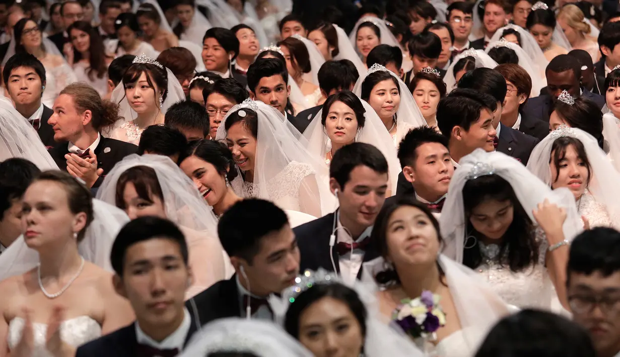 Ekspresi sejumlah pasangan saat mengikuti pernikahan massal di Pusat Perdamaian Cheong Shim di Gapyeong, Korea Selatan, (7/9). Pernikahan massal di Korsel sudah sering diadakan dan sudah menjadi ciri khas gereja terseubt. (AP Photo / Ahn Young-joon)