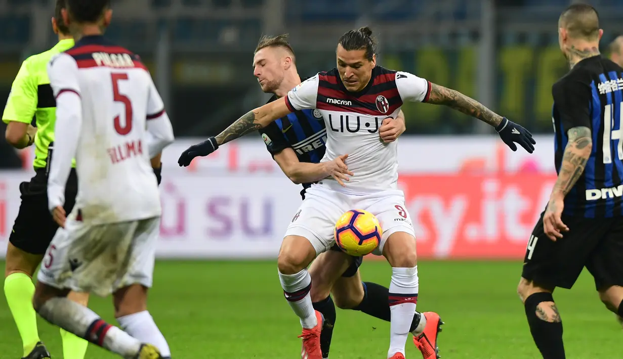 Aksi penyerang Bologna, Federico Santander berduel dengan Milan Skiniar pada lanjutan Serie A yang berlangsung di stadion Giuseppe Meazza, Milan, Minggu (3/2). Inter Milan kalah 0-1. (AFP/Miguel Medina)