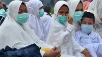 Umat muslim mengenakan masker saat mendengarkan ceramah usai melaksanakan salat Idul Adha di halaman Masjid Raya Annur, Kota Pekanbaru, Riau, Minggu (11/8/2019). Kabut asap imbas kebakaran hutan dan lahan (karhutla) menyelimuti pelaksanaan salat Idul Adha 2019 di Pekanbaru. (Wahyudi/AFP)